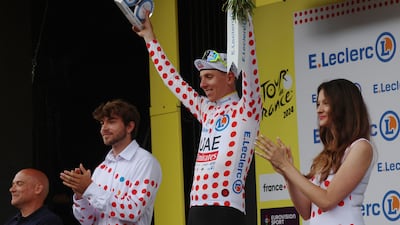 UAE Team Emirates' Tadej Pogacar celebrates on the podium wearing the King of the Mountains polka-dot jersey. Reuters