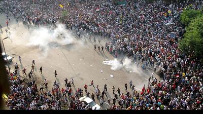 Supporters of ousted president Mohamed Morsi run for cover from tear gas during clashes with riot police along Ramsis street in downtown Cairo, Egypt. Ahmed Gamel / AFP