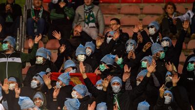 Saint-Etienne's supporters wear protective face masks as they attend the French L1 football match between Metz and Saint-Etienne. AFP