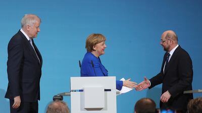 Done deal? Angela Merkel shakes hands with Martin Schulz, leader of the Social Democrats, after a coalition agreement hammered out following overnight coalition talks. Krisztian Bocsi/Bloomberg