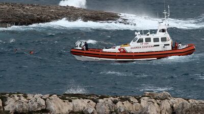 A rescuer in the water coordinates with a coast guard boat after retrieving a body at sea near the Sicilian island of Lampedusa on Sunday. AP