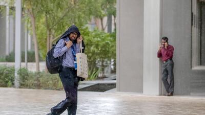 People rush for shelter from the rain at NYU Abu Dhabi. Victor Besa/The National