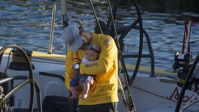 Abu Dhabi Ocean Racing's Daryl Wislang holds his daughter after arriving at Cape Town on Wednesday with the crew winning the first leg of the Volvo Ocean Race. Rodger Bosch / AFP