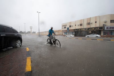 A cyclist navigates a flooded road in Khor Fakkan. Ruel Pableo for The National
