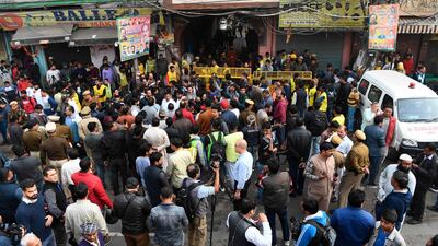 Onllokers and members of the media gather as police personnel block a street leading to a factory site after a fire broke out, in Anaj Mandi area of New Delhi. At least 43 people have died in a factory fire in India's capital New Delhi, with the toll still expected to rise. AFP