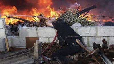 A man tries to extinguish a fire following shelling by forces loyal to Syria's President Bashar Al Assad, according to the Free Syrian Army, in the Jobar area in Damascus.