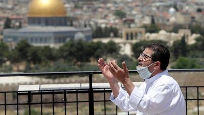 A man prays in east Jerusalem's Mount of Olives, overlooking the Dome of the Rock and Al Aqsa mosque compound, which remains shut to prevent the spread of coronavirus during Ramadan. AP Photo