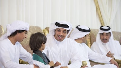 Sheikh Mansour bin Zayed speaks with a young guest while visiting the family of Obaid Al Shamsi. Seen with Sheikh Abdullah bin Zayed and Ahmed Juma Al Zaabi, Deputy Minister of Presidential Affairs. Ryan Carter / Crown Prince Court - Abu Dhabi