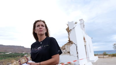 A woman holds a religious icon as she stands in front of a damaged church in Xerokampos village on the island of Crete in Greece, where a 6.3-magnitude earthquake occurred on October 12, 2021. EPA