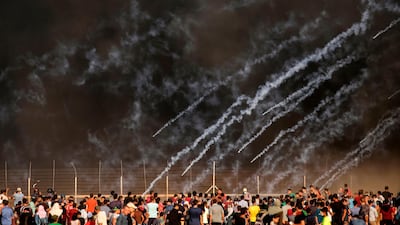 Tear gas canisters fired by Israeli forces landing amid protesters during a demonstration along the border with Israel east of Gaza City on July 13. AFP