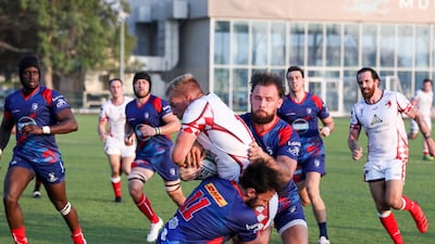 Dave Funston holds on tight as he's tackled. Khushnum Bhandari / The National