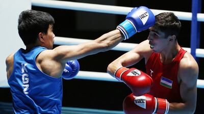 Uzbekistan's Abdulmalik Khalokov (R) and Kyrgyzstan's Sanzhai Seidekmatov in a tense battle at the Kuwait International Boxing Championship.