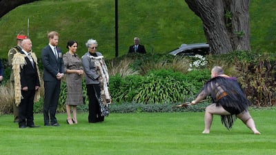 Britain's Prince Harry (second left) and his wife Meghan (third left), chat with Maori elders as a warrior makes a traditional challenge during an official welcoming ceremony at Government House in Wellington. AFP