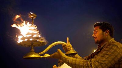 An Indian Hindu priest rotates a traditional oil lamp as he performs evening rituals at the Sangam, the confluence of the Rivers Ganges, Yamuna and mythical Saraswati during the annual traditional fair of Magh Mela in Allahabad. Rajesh Kumar Singh / AP Photo