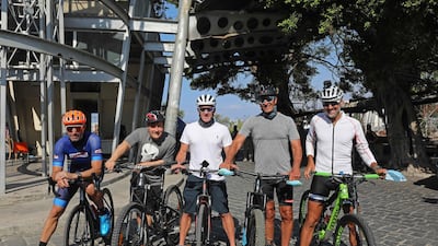 US former professional cyclist Lance Armstrong and Lebanese sportsman Maxime Chaya along with local and foreign cyclists pose for a picture prior to "Bike for Beirut" charity tour at the site of the August 4 port explosion. AFP