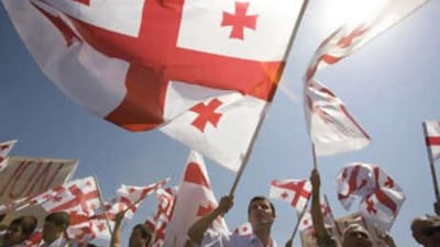 Dozens of refugees and activists yelling 'Russia out" wave Georgia's flag while marching towards a Russian check-point near Kaspi, on the road from Tbilisi to Gori.