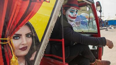An Iraqi demonstrator dressed in a Joker outfit poses for a picture inside as he sits inside a Tuk-Tuk during an anti-government demonstration by Basra University students in the southern city of Basra. AFP