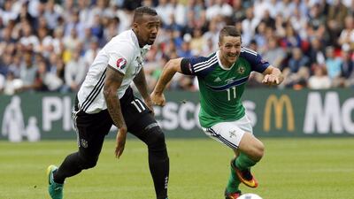 Northern Ireland's Conor Washington, right, and Germany's Jerome Boateng go for the ball during the Euro 2016 Group C soccer match between Northern Ireland and Germany at the Parc des Princes stadium in Paris, France, Tuesday, June 21, 2016. (AP Photo/Michael Probst)