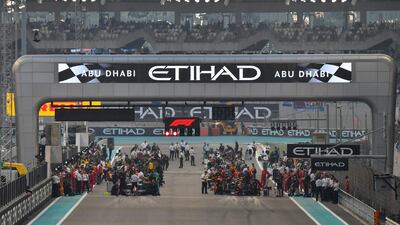 Cars and mechanics are pictured on the grid ahead of the final race of the season. AFP