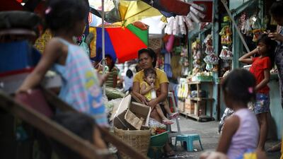 A Filipino mother and child are pictured in a street in Quezon City, east of Manila, Philippines. The Philippines Supreme Court upheld the constitutionality of a national birth control law 08 April 2014, but nullified some of its provisions. Ritchie B Tongo / EPA