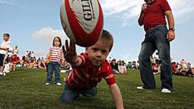 Two-year-old Ewan Fryer enjoys the first day of the Dubai Rugby Sevens yesterday. A tournament older than the country itself.