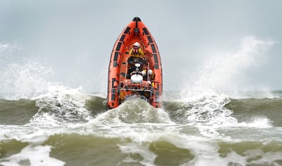 An RNLI Lifeboat crashes through waves. PA