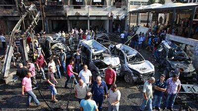 People gather at the site of twin car bombings in the northern city of Tripoli, Lebanon. The tiny country is being consumed by the raging war next door in Syria (AP Photo/Bilal Hussein)
