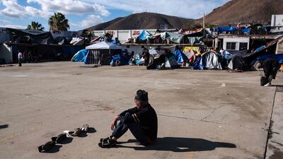 A migrant dries his shoes at a new temporary shelter east Tijuana, Baja California State, Mexico. AFP
