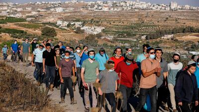 Israeli settlers gather on a hill next to the Palestinian town of Halhul, north of Hebron in the occupied West Bank, as they attend a rally against US President Donald Trump's peace plan. AFP