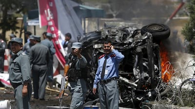 Policemen stand at the site of a car bomb blast at the entrance gate to the Kabul airport. Ahmad Masood / Reuters