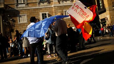A man holds Spanish and European Union flags and a board reading: "Victory" outside the Palau de la Generalitat in Barcelona, Spain on October 30, 2017. Francisco Seco / AP Photo