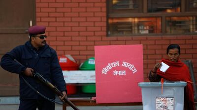 A woman casts her vote as an armed guard look on in Bhaktapur. Navesh Chitrakar / Reuters