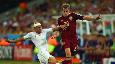Sofiane Feghouli of Algeria tackles Dmitri Kombarov of Russia during their match on Thursday at the 2014 World Cup in Curitiba, Brazil. Clive Rose / Getty Images