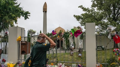A member of the emergency services holds his head as he views flowers and tributes outside Al Noor mosque after it was officially reopened following last week's attack, on March 23, 2019. Getty Images