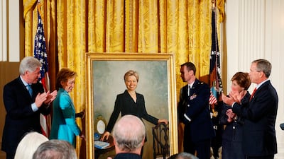 Mr Clinton and then-president George W Bush and his wife Laura, applaud as Mrs Clinton's portrait is unveiled in 2004. AP
