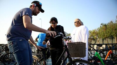 Edward Strick, left, manager of Fun Ride Sports, helps Neenah Al Ansari select a bike in Abu Dhabi. Ravindranath K / The National