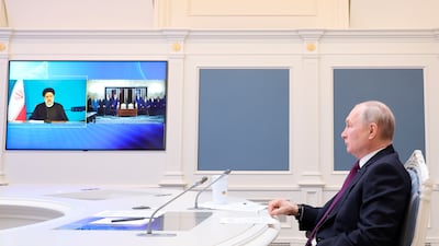 Russian President Vladimir Putin, right, and Iranian leader Ebrahim Raisi witness the signing an agreement on the construction of the Rasht-Astara railway by video on May 17, 2023. AP