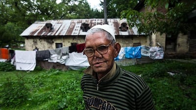 A leper patient stands in front of one of the huts at the hospital.