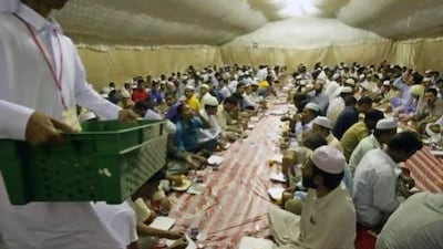 Labourers break their fast in a Red Crescent tent after the first day of Ramadan in Mussaffah in 2009. The charity has historically given out about 30,000 iftar meals over the course of the month. Jaime Puebla / The National