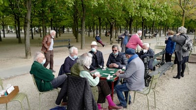 People wearing protective face masks play cards in the Luxembourg Garden in Paris, France. AFP