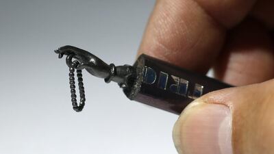 A Buddha hand carved from the tip of a pencil.