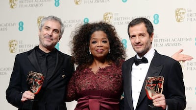 British producer David Heyman, right, and Mexican director Alfonso Cuaron, left, pose in the press room after winning the Outstanding British film award for ‘Gravity’ with the award presenter, US TV host and actress Oprah Winfrey at the 2014 EE British Academy Film Awards ceremony at The Royal Opera House in London. Andy Rain / EPA