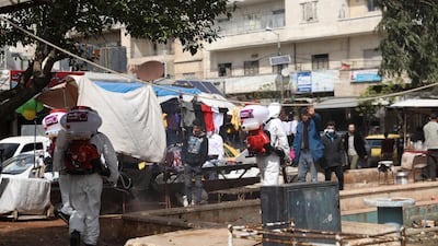 Volunteers from 'Violet Organisation', a local non government organisation, wear personal protective equipment during a disinfection operation in Idlib, Syria. EPA