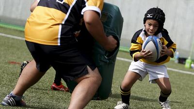 A member of Katsushika Rugby school runs towards a coach with a ball during one-day class this month in Tokyo. Yuya Shino / Reuters