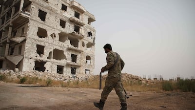 A Syrian fighter walks in the rebel-held Al Rashidin district of western Aleppo's countryside near Idlib province. AFP