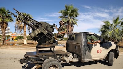 Members of the Libyan National Army loyal to Khalifa Haftar man turrets mounted in the back of pickup trucks as they remain on guard duty. AFP