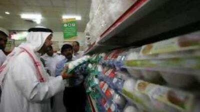 Hashim el Nuaimi, the director of the Emirates Society for Consumer Protection, inspect prices at the Sharjah Co-Operative Supermarket.