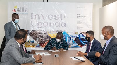 Matia Kasaija, Uganda’s Minister of Finance, Planning and Economic Development, signs an investment deal at Expo 2020 Dubai. Photo: UIA