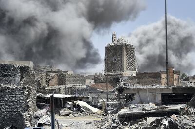 Smoke billows in the background behind the base of Mosul's destroyed ancient leaning minaret, known as the "Hadba" (Hunchback), in the Old City on June 30, 2017, after the area was retaken by the Iraqi forces from Islamic State (IS) group fighters. Explosions on June 21 evening levelled the mosque, where Abu Bakr al-Baghdadi gave his first sermon as leader of the Islamic State group and its ancient minaret. - Iraq will declare victory in the eight-month battle to retake second city Mosul from jihadists in the "next few days," a senior commander said on June 30, 2017. Iraqi forces launched the gruelling battle for Mosul on October 17, 2016, advancing to the city and retaking its eastern side before setting their sights on the smaller but more densely populated west. (Photo by FADEL SENNA / AFP)