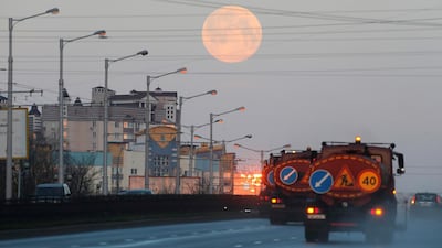 Traffic passes along a road in Minsk, Belarus, as the pink supermoon hangs in the sky. Reuters